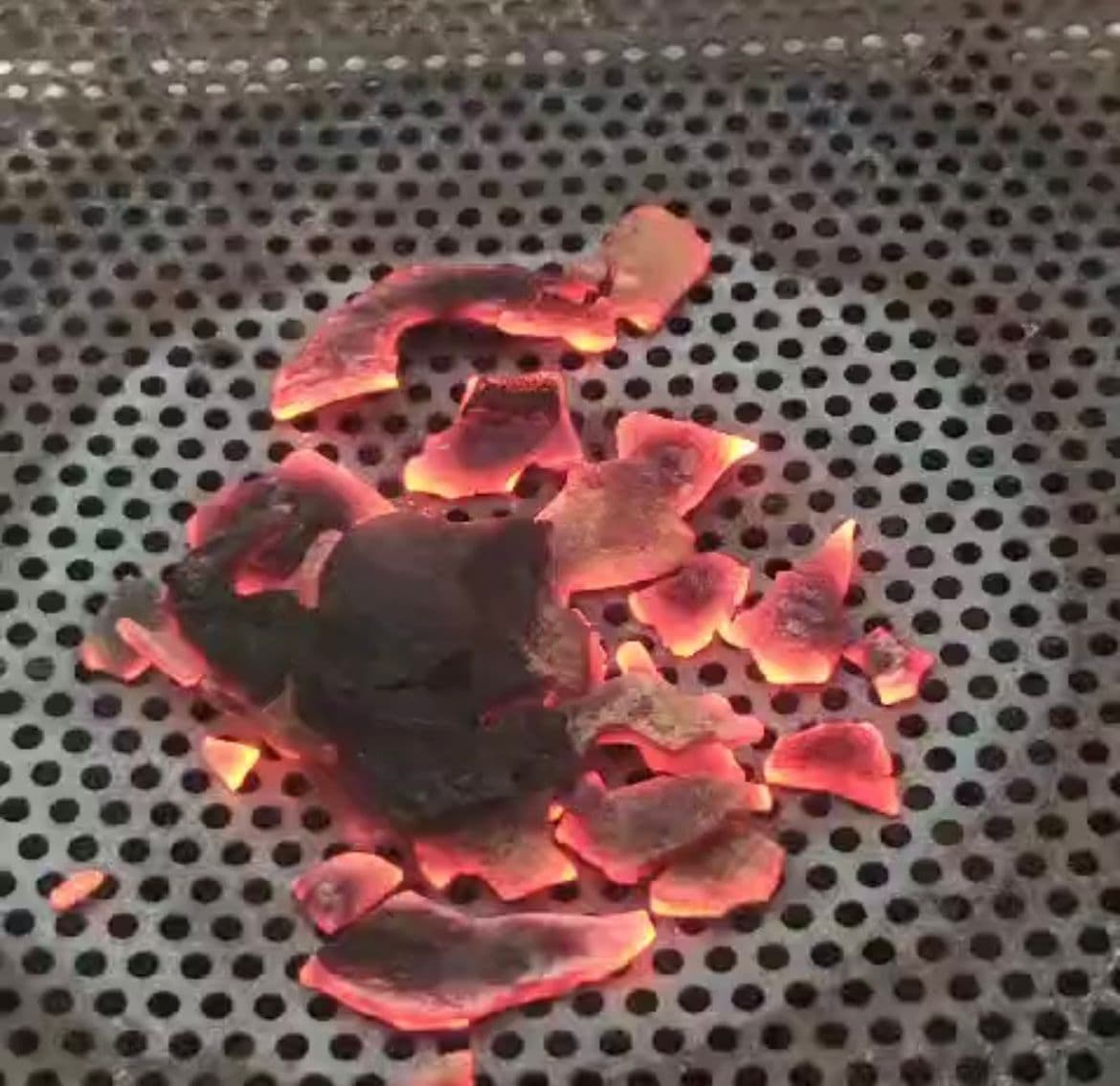 Glowing coconut shell charcoal during carbonization quality check